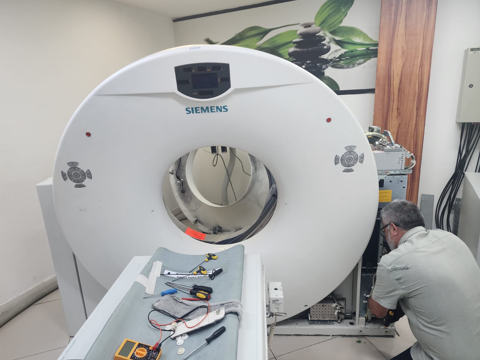 Técnico Cardiotech realizando manutenção em tomógrafo Siemens